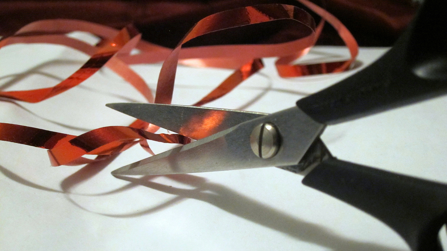 Scissors prepare to cut through a tangle of yarn