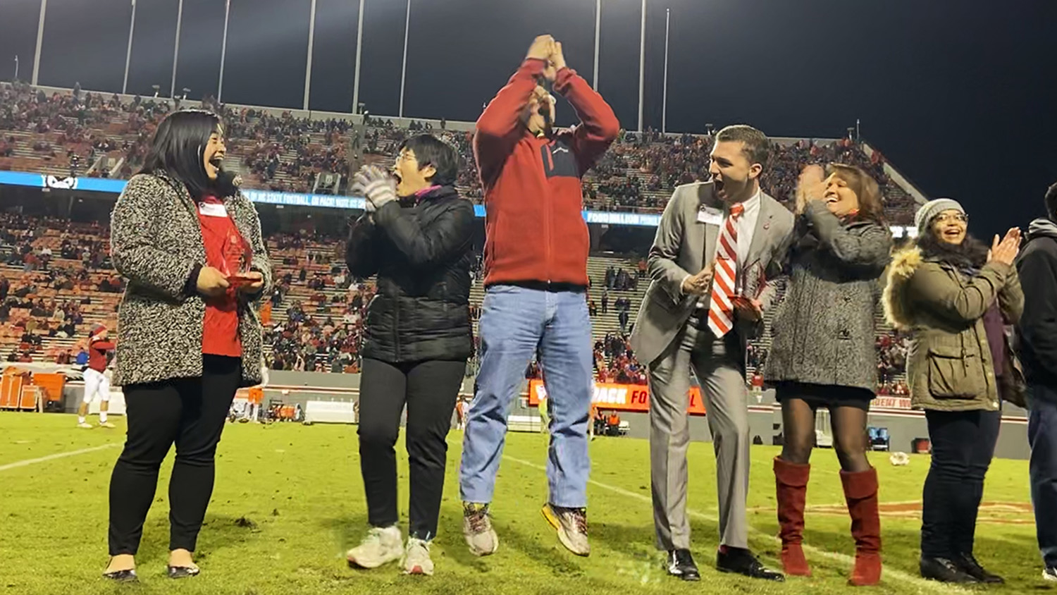 Sam Chan holds Leader of the Pack award at Carter-Finley Stadium