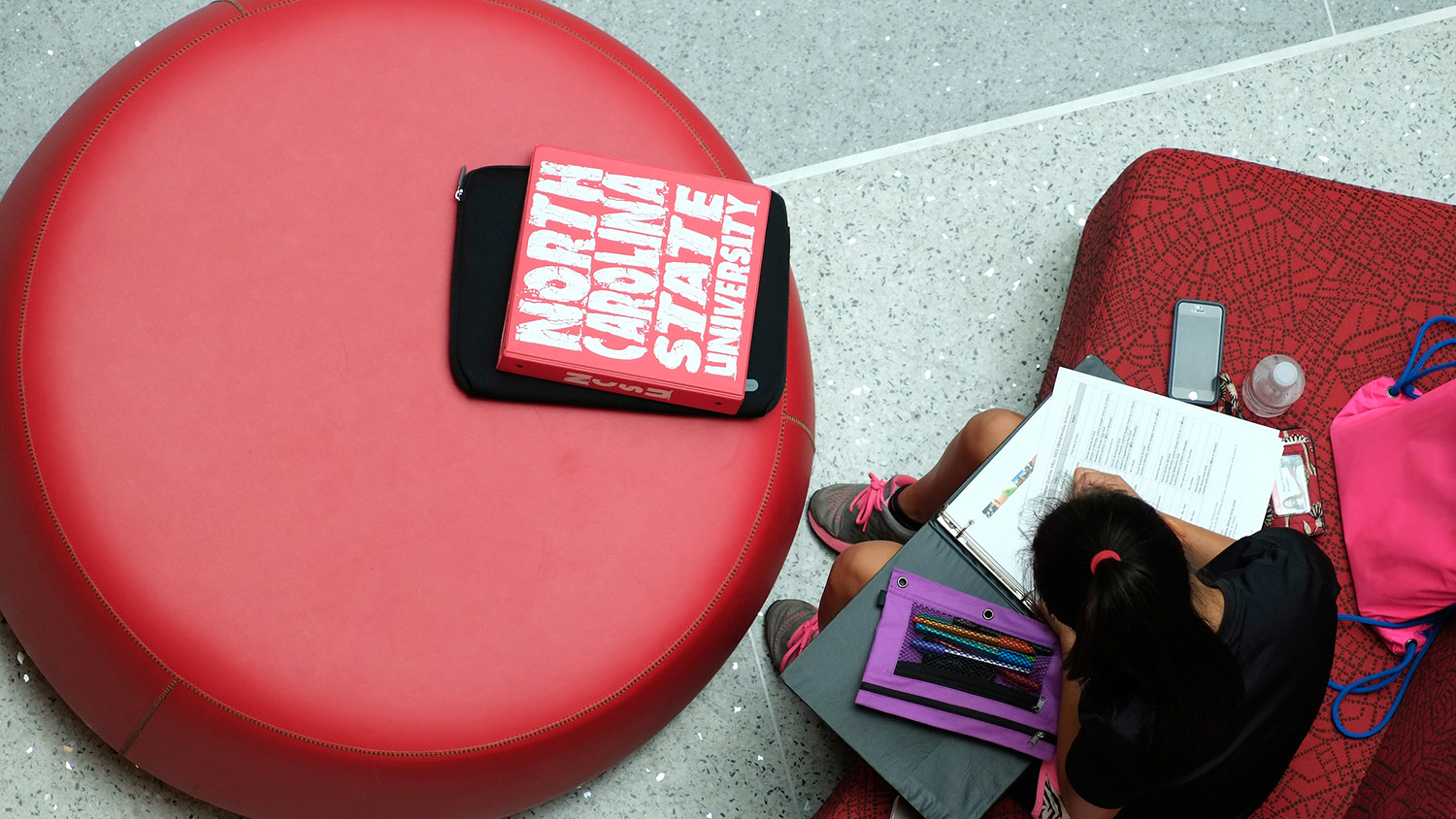 student studying while sitting on red chair