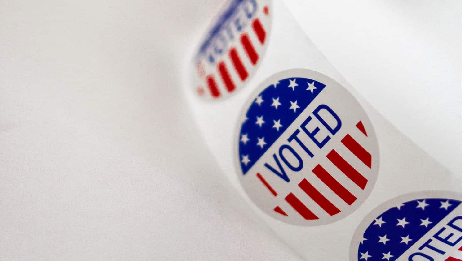 a roll of stickers that say "I Voted" is unfurled across a white background