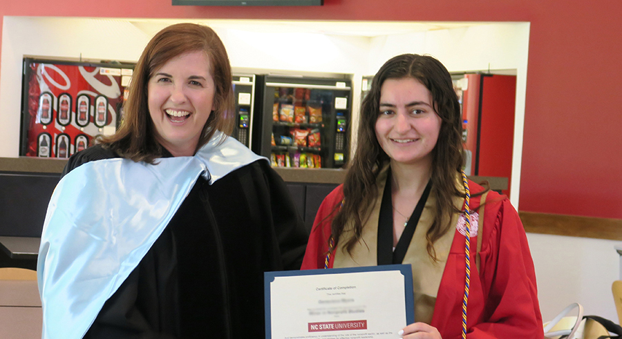 professor with student holding certificate