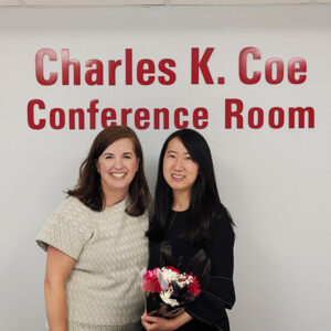 Amanda Stewart and Yinman Zhong pose with flowers after her Ph.D. defense