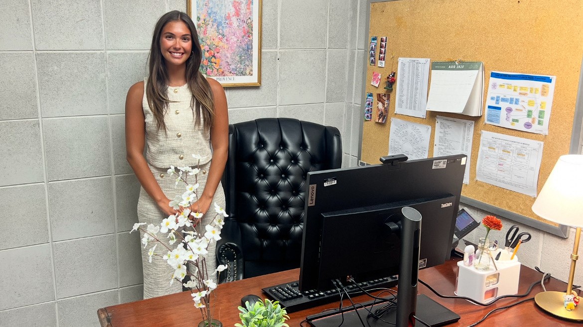 Kendall Rosenburg standing behind her desk in her office at the NCGA.